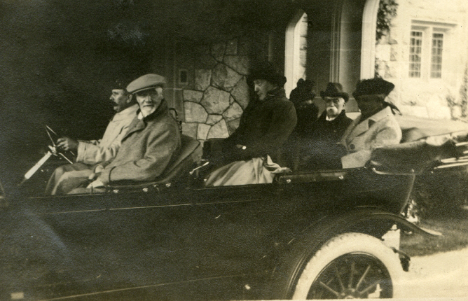 Archival photo: Passengers riding in old-fashioned car in front of Hatley Castle