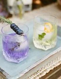 Two cocktails: one purple with olives and lavender, one clear with lemon