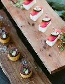 Two types of canapes displayed on wood with green garnish